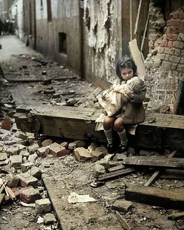 Маленькая девочка сидит на руинах своего разрушенного дома после налета немецкой бомбы на Лондон во время битвы за Британию 24 августа 1940 года
