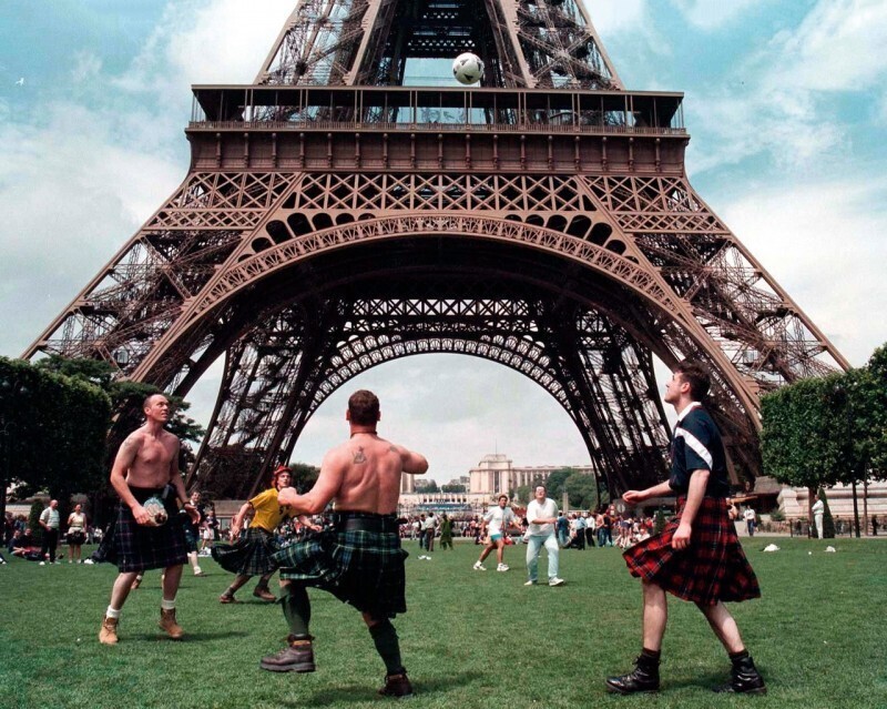 Шотландские фанаты разминаются под Эйфелевой башней перед первым матчем чемпионата мира по футболу, 1998 год.