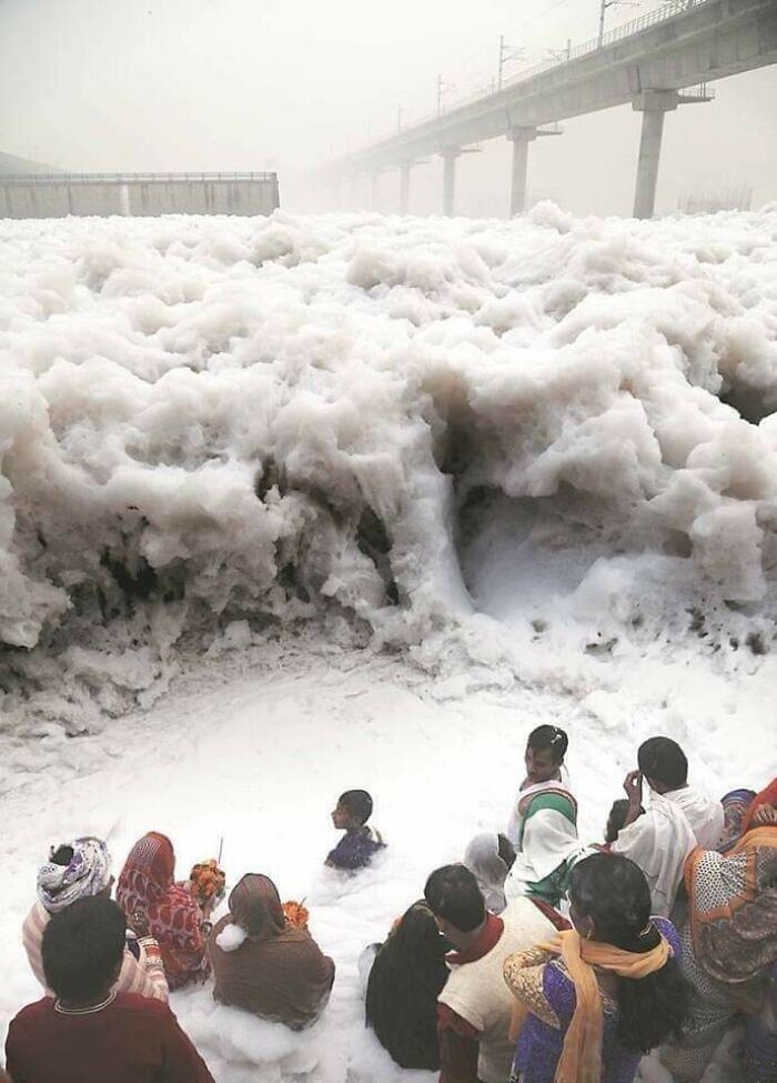 9. Люди молятся у реки Ямуна в Индии, которая вспенилась из-за промышленных отходов