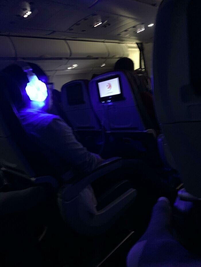 Пассажиры, которые хвастаются своими светящимися аксессуарами в темном ночном самолете