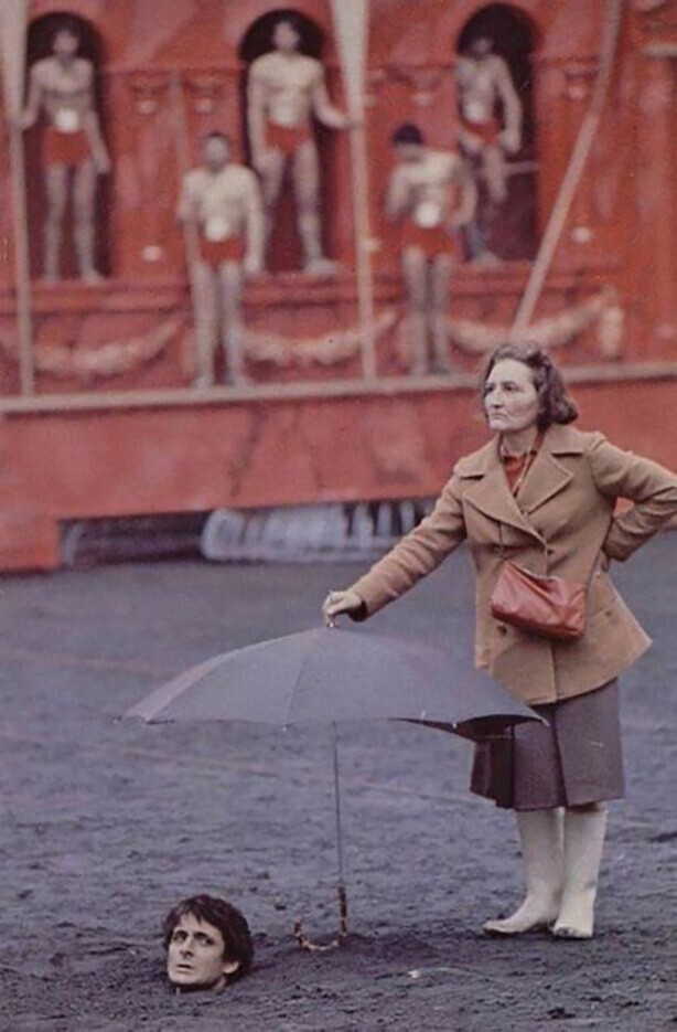 Работница съёмочной группы прикрывает зонтом от дождя актёра на съёмках фильма "Калигула", 1979 год