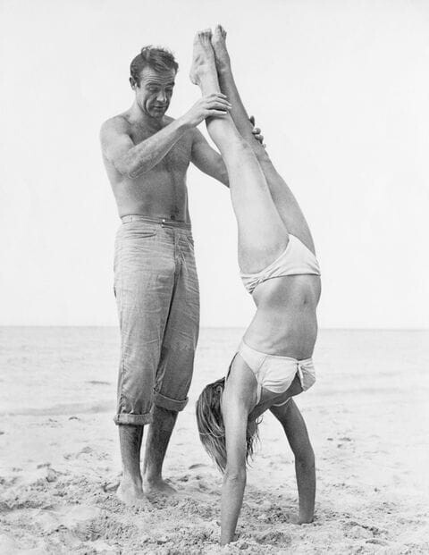 На пляже. Шон Коннери и Урсула Андресс (стойка на руках в белом бикини) на съёмках "Доктор Ноу".