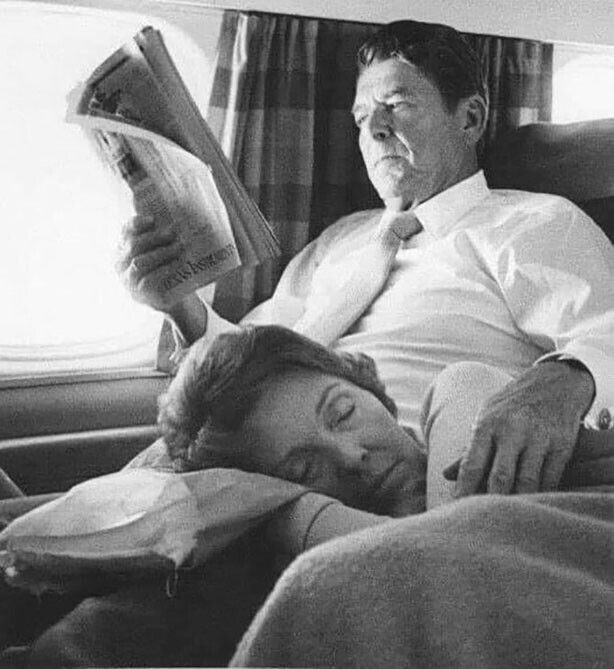 Уставшая Нэнси Рейган дремлет на коленях у мужа во время полета. 1976 год