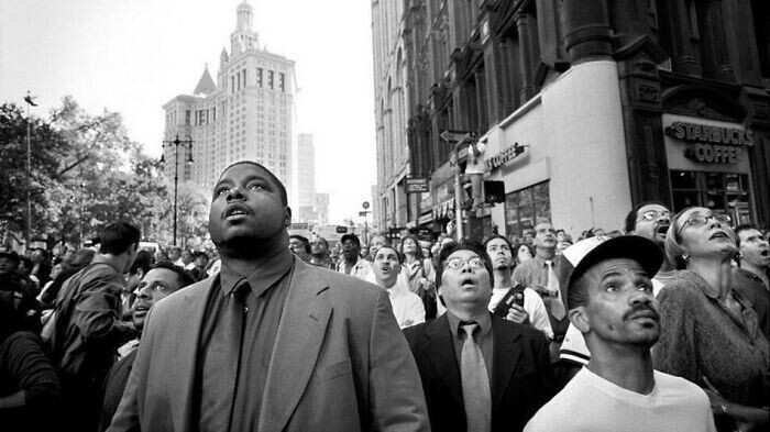 25. Люди на улице с ужасом и недоверием смотрят, как падают башни-близнецы 11 сентября