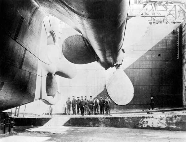 "Титаник" на верфи: рабочие стоят под его винтами, чтобы показать, как он огромен