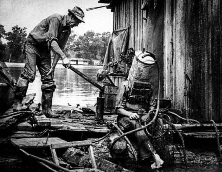 Ловец жемчуга на Миссисипи готовится к очередному "заходу" на дно, 1938 год. В качестве шлема - старый топливный бак от автомобиля. В таком аппарате он мог погружаться на глубину до 21 метра