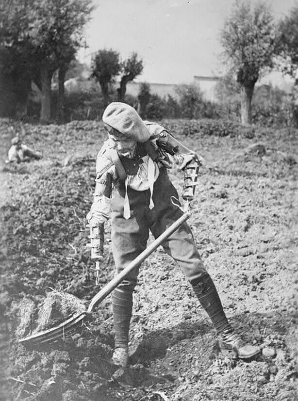 Раненый британский солдат, которому ампутировали обе руки по локоть, работает на ферме, Франция. 1918 год