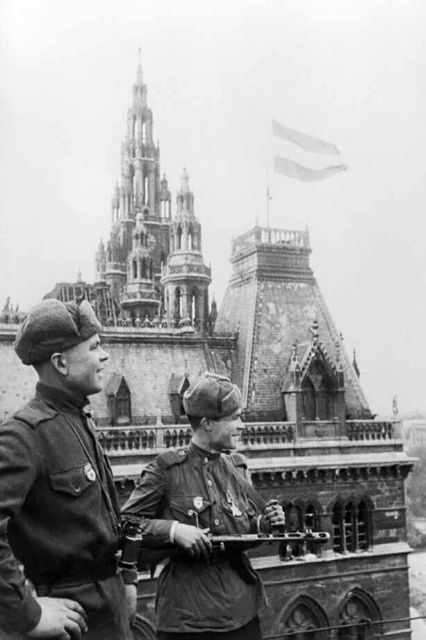 Советские солдаты у городской ратуши Вены, над крышей которой поднят государственный флаг Австрии после взятия города 13 апреля 1945 год