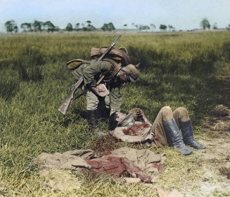 Немецкий солдат даёт флягу с водой тяжело раненому русскому солдату во время боёв в Галиции, 1915 год
