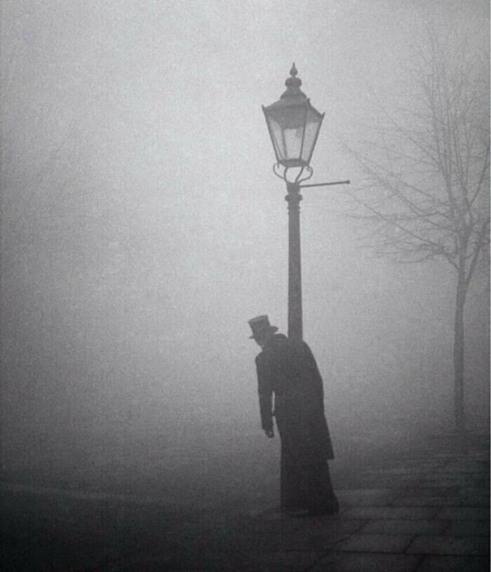 15. Пьяный мужчина в цилиндре и фраке обнимается с фонарем, Лондон, 1934 год. Фото Билла Брэндта