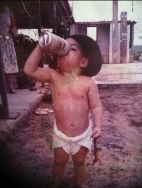 6. Ребенок пьет пиво и держит в одной руке крокодиленка. Австралия, около 1991 г. 