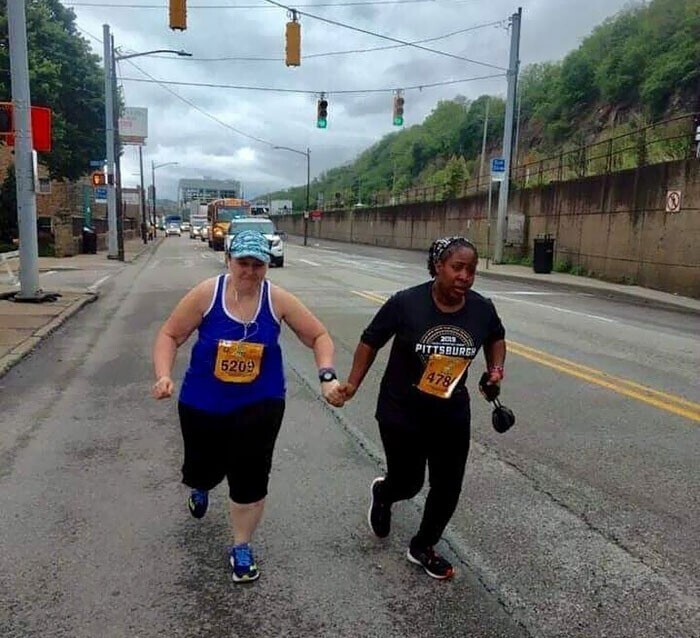 Два последних бегуна марафона в США держат друг друга за руки, чтобы не сдаться