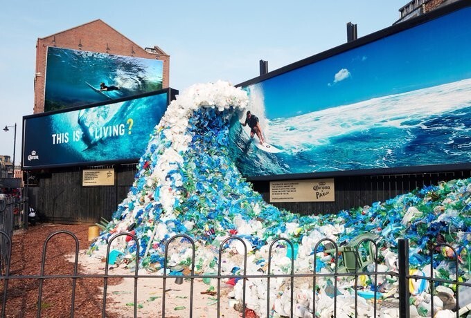 Надпись под рекламным щитом гласит: “Эта волна отходов содержит среднее количество пластикового мусора, которым засорены пляжи в Великобритании"