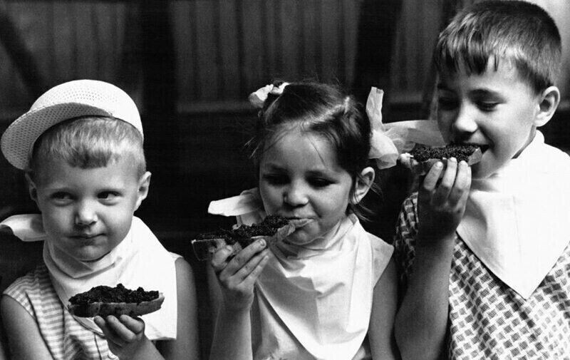 Дети наслаждаются бутербродами с черной икрой в детском саду. Москва,1965 год
