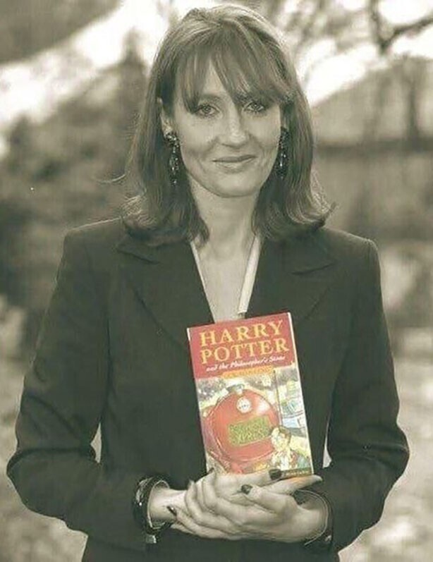 Джоан Poулинг держит в рукax пepвый опубликованный роман о приключениях Гарри Поттера, 1997 гoд