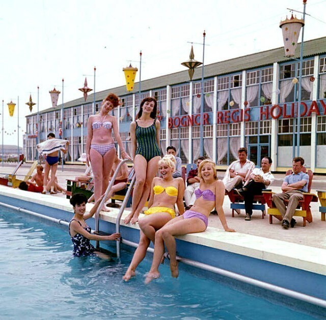 Молодые женщины в бикини и купальных костюмах позируют у бассейна на курорте Батлинс в Богнор-Реджис, Англия, 1964 г.