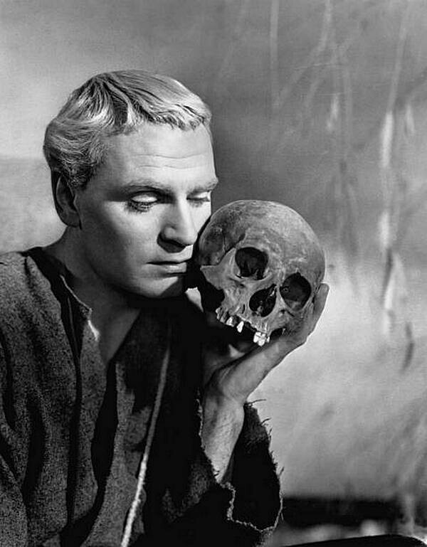 Лоуренс Оливье в роли шекспировского принца Датского Гамлета держит череп Йорика в сцене из его киноверсии «Гамлета».