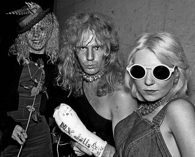 Басист Артур Кейн из глэм-рок-группы New York Dolls позирует для портрета с молодыми поклонницами, включая Сэйбл Старр (слева), примерно в 1973 году в Лос-Анджелесе, Калифорния.