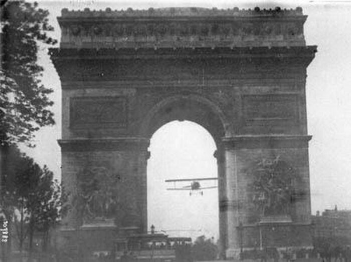 Шарль Годфруа пролетает на своем Ньюпорте 11 “Бебе” через Триумфальную арку в Париже 7 августа 1919 год