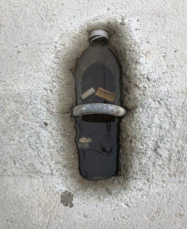 Это не упавшая бутылка, а просто небольшая яма в бетоне