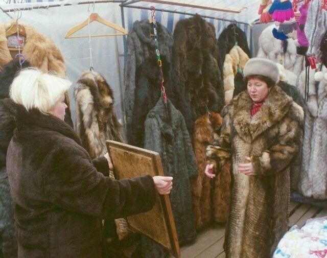 Женщина выбирает себе на рынке шубу, Россия, 1990-е годы