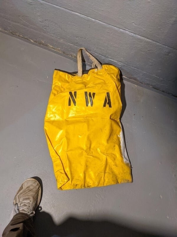 9. «Желтая сумка на молнии с надписью NWA, была спрятана в стене подвала. Примерно 3 фута (около метра) высотой, сверху толстая черная молния. Что это?»