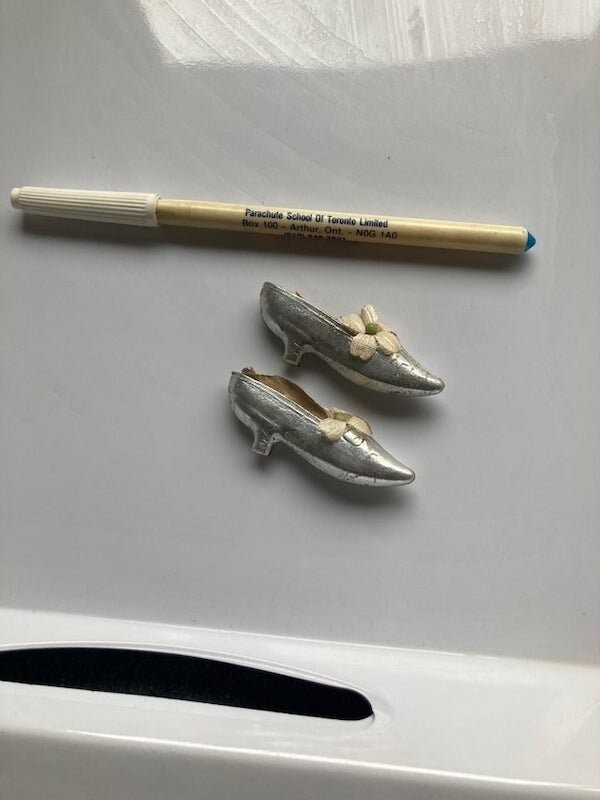 11. «Крохотные серебряные туфли, найдены в личных вещах недавно умершего человека (ручка для масштаба). Что это?»