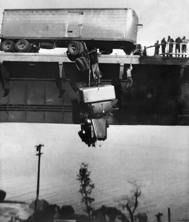 На фото Пол Оверби, один из двух водителей, застрявших в кабине грузовика. Его вытягивают на веревке на мосту Пит-Ривер через озеро Шаста недалеко от Реддинга, Калифорния, 3 мая 1953 года
