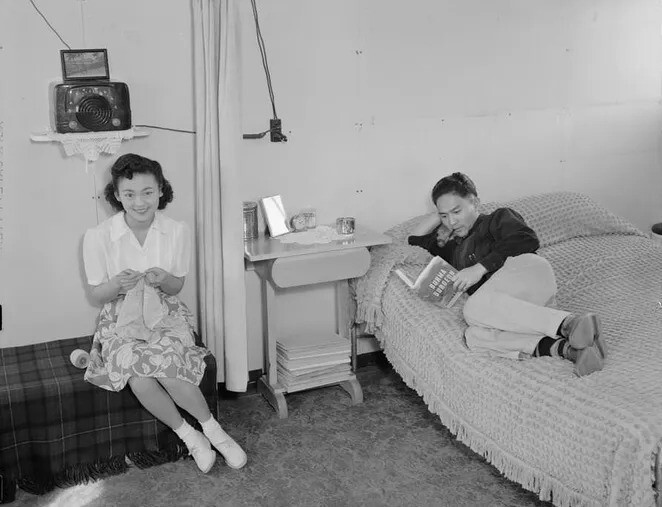 24. Миссис Симидзу работает на диване с кружевом, мистер Симидзу читает рядом на кровати.