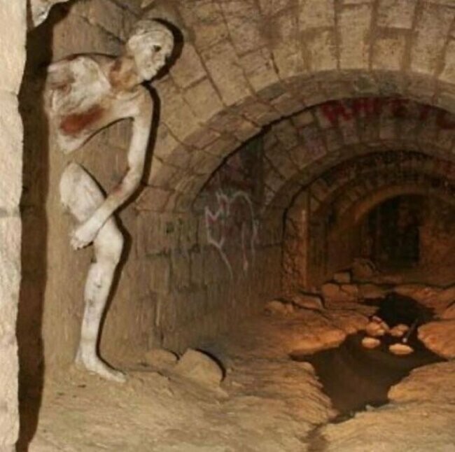 18. Скульптура "Проходящий через стену" (Le Passe-muraille) в парижских катакомбах