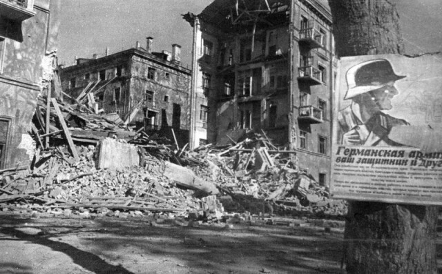 Немецкий плакат "Германская армия — ваш защитник и друг" на разрушенной улице города Брянска, 1943 год