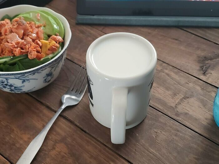 Полная чашка молока кажется перевернутой вверх дном