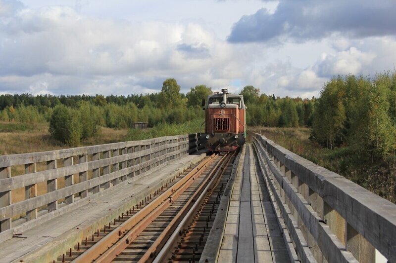 Поезд Алапаевской узкоколейки следует по мосту через реку Кыртомку