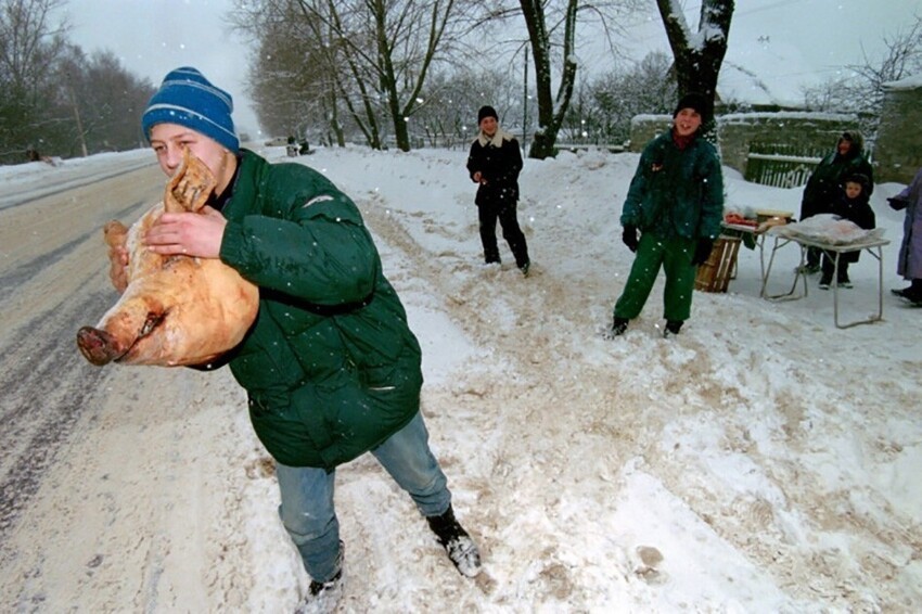 Подросток, пытающийся продать свиную голову проезжающим по трассе, ведущей в Москву. Россия. 1994 год
