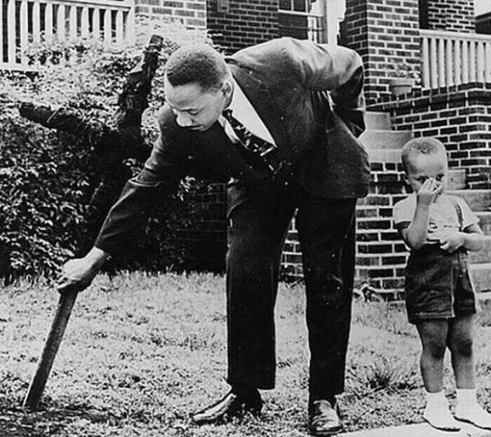 23. Мартин Лютер Кинг-младший убирает сгоревший крест со своего двора, 1960 год