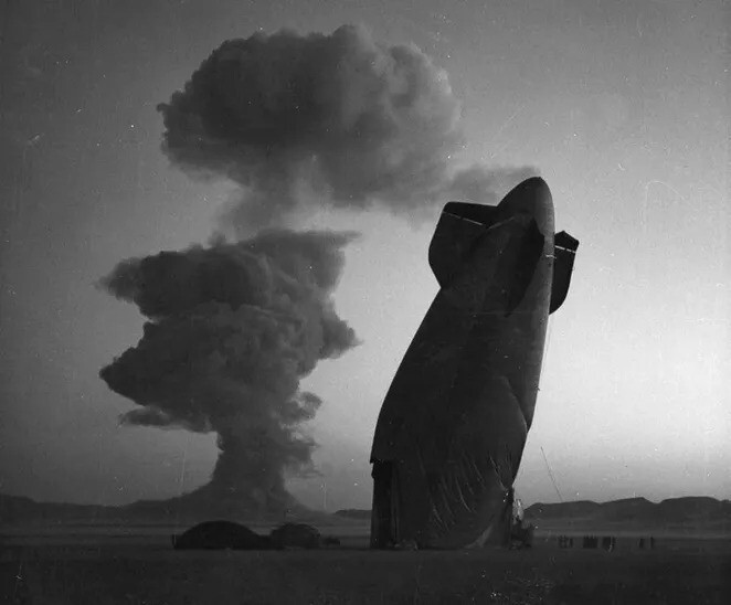 30. На полигоне ядерных испытаний в Неваде, 7 августа 1957 года, хвост дирижабля ВМС США сфотографирован на фоне облака ядерного взрыва