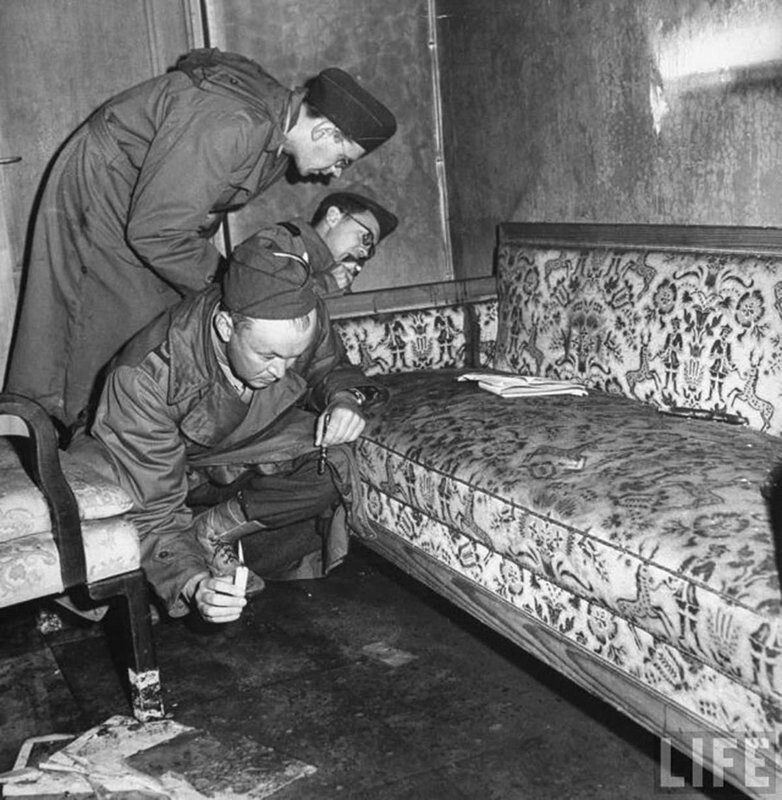 14. Американские солдаты осматривают диван, на котором покончили жизнь самоубийством Адольф Гитлер и Ева Браун, 1945 год.