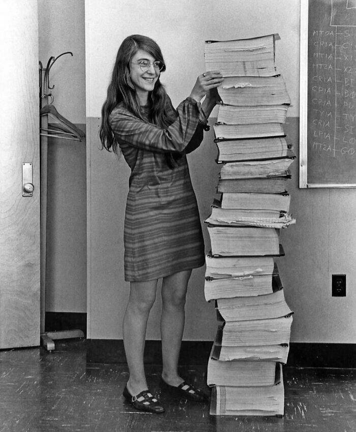 4. Ведущий инженер-программист НАСА по программе «Аполлон» Маргарет Гамильтон стоит рядом с написанным от руки кодом, который отправил человечество на Луну. 1969 год