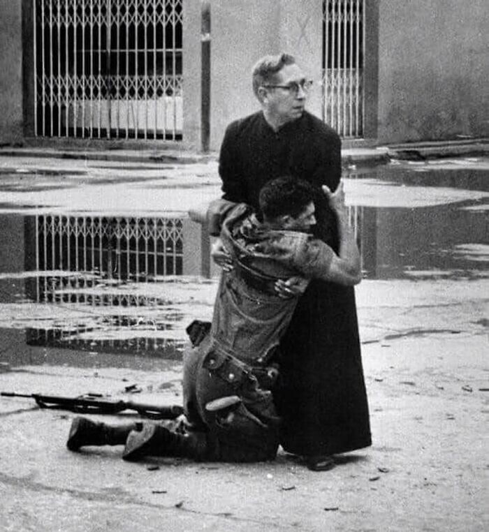 8. Священник держит умирающего солдата, пока вокруг них летают пули. Венесуэла, 1962 год