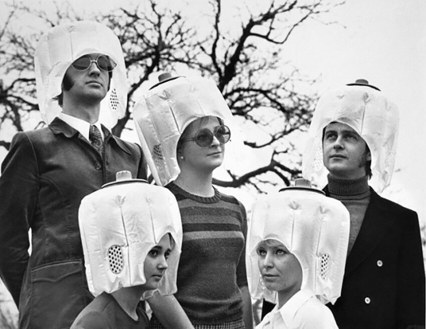 Группа мужчин и женщин, использующих чудаковатый фен для сушки волос, 70-е