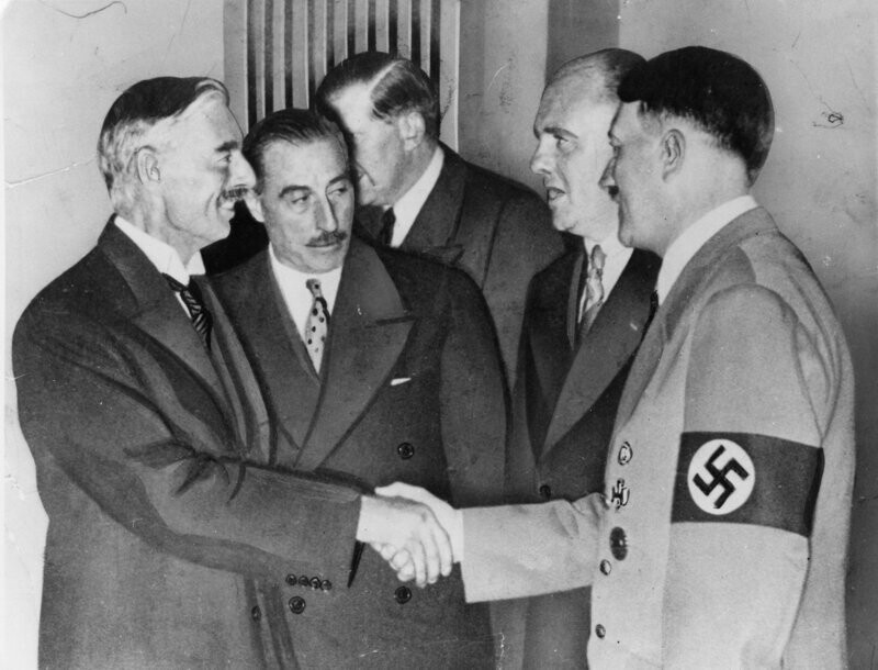 Невилл Чемберлен и Адольф Гитлер подписывают соглашение, разрешающее Гитлеру аннексию Судетской области