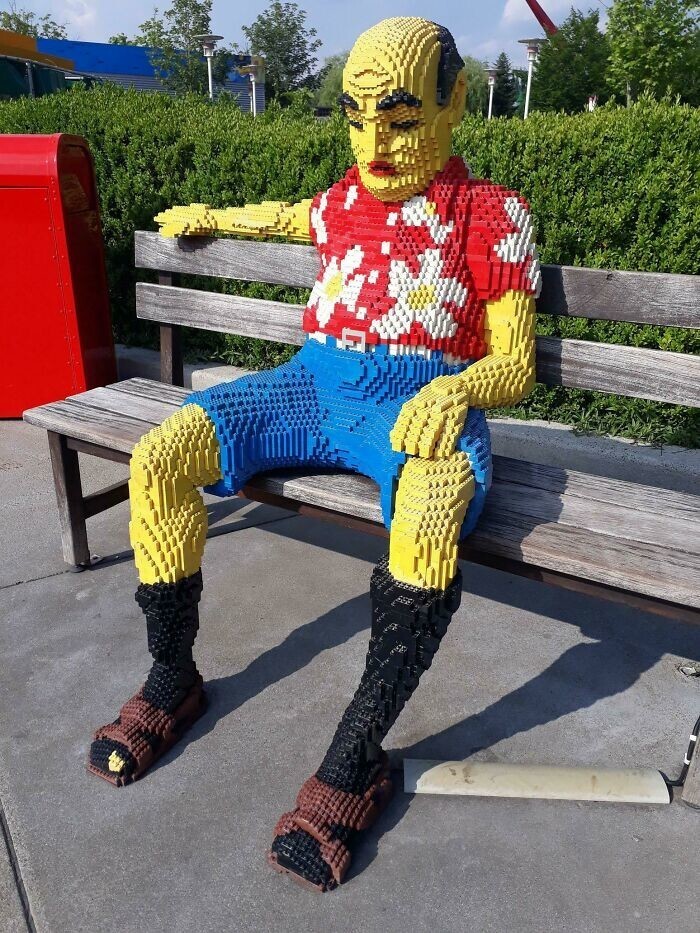 28. Перед немецким Леголендом на скамейке сидит пожилой немец из LEGO в сандалиях с носками