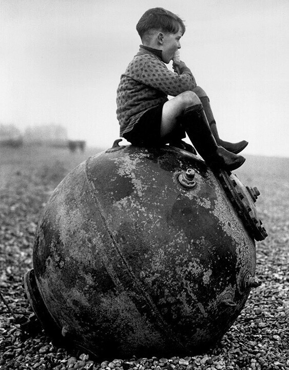Мальчик сидит на морской мине на пляже в Кенте, Англия, 1945 год