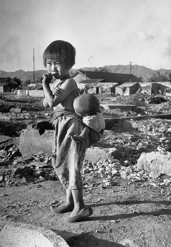 Южная Корея. Девочка сирота со своим младшим братом посреди развалин города во время Корейской войны, 1950 год