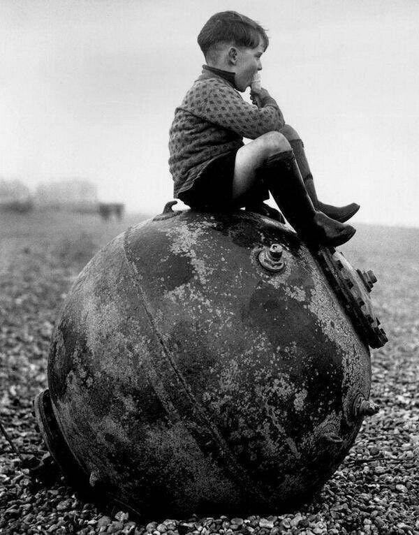 12. Мальчик сидит на морской мине на пляже в Кенте,  Англия, 1945 год
