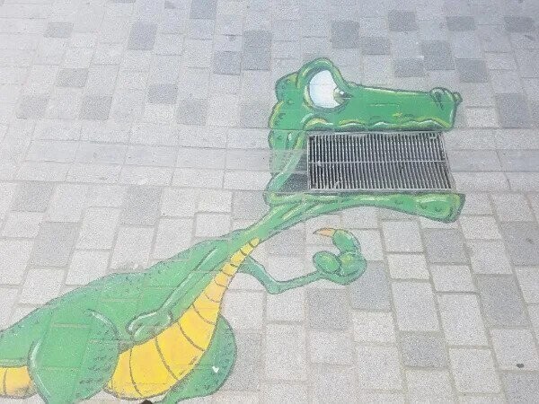 Уличный художник использовал водосток как часть рисунка