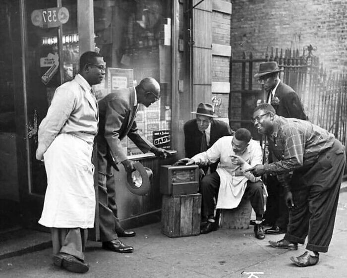 22. Мужчины в Гарлеме собираются перед магазином, чтобы послушать радио, 1940 год
