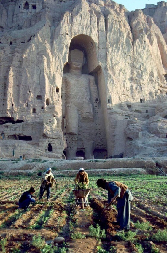Фермеры работают под Великим Буддой 4-5 веков в Бамиане, Афганистан, 1992 г. (разрушен талибами в 2001 г.)