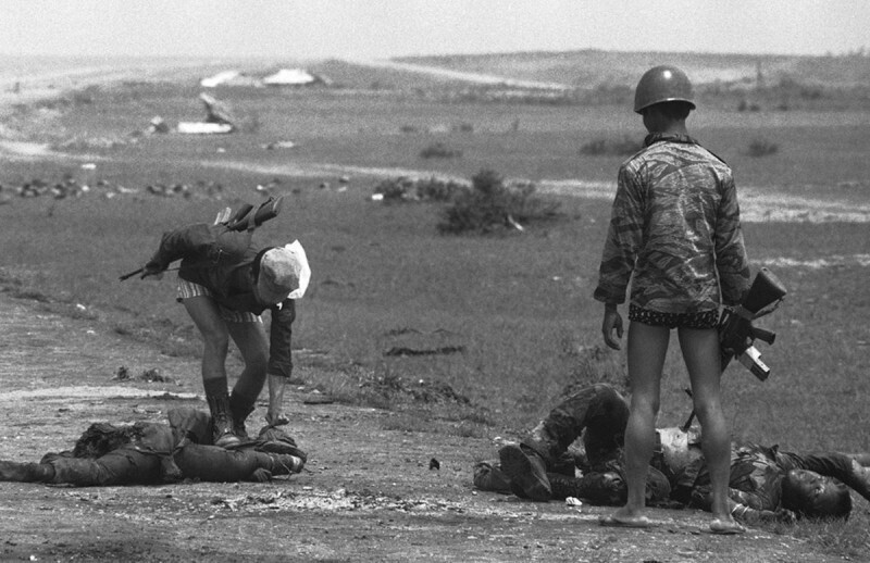 Южновьетнамские морские пехотинцы проверяют тела убитых северовьетнамских солдат на наличие сигарет и ценностей. 5 мая 1972 год