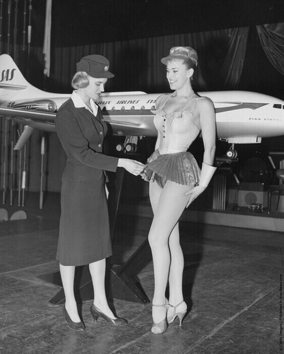 12 января 1959: шведская стюардесса Birgitta Lindman, из шведской авиакомпании SAS, осматривает костюм танцовщицы после слухов о том, что у стюардесс слишком короткие юбки.